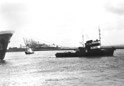 Mit Hilfe von Schleppschiffen verläßt ein Schiff im Jahr 1967 den Emder Hafen