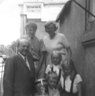 Schwarz-Weiss-Photo aus dem Jahr 1967 von der Struckmannstraße Ecke Sprengerstraße 46: Familie Thomasius an Rolfis erstem Schultag auf der vom Vorgarten zur Veranda ihrer Wohnung im Hochparterre in der Sprengerstraße 46 führenden Treppe.
