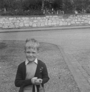 Schwarz-Weiss-Photo von der Sprengerstraße Ecke Struckmannstraße in Hildesheim: Ein Junge an seinem ersten Schultag.