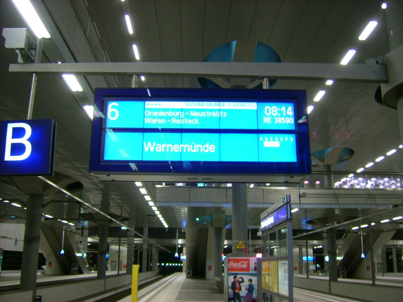 Farbphoto von dem Gleis 6 im Tiefgeschoss des Berliner Hauptbahnhofs im Juni 2009. Blick auf die den Warnemünde-Express ankündigende Anzeigetafel. Photograph: Bernd Paepcke.
