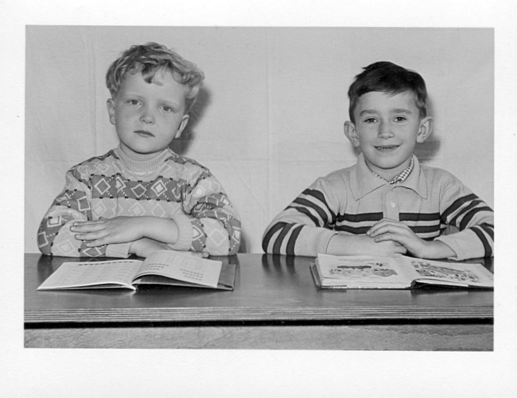 Zwei Schüler einer ersten Volksschulklasse hinter ihrer Schulbank und aufgeschlagenen Schulbüchern in der Bahnhofsschule in Hildesheim im Jahr 1960.