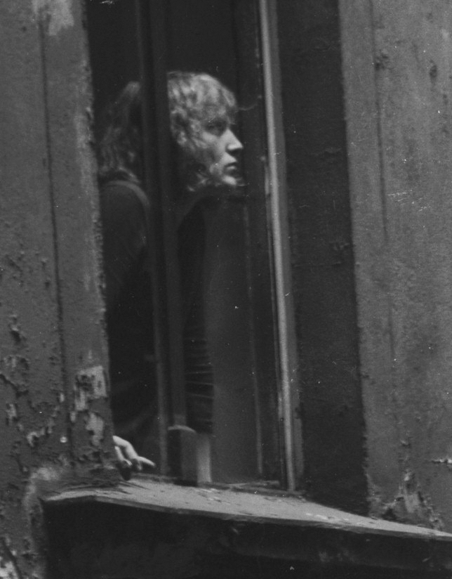 Schwarz-Weiß-Foto: Erwin Thomasius guckt im Jahr 1973 aus einem Fenster seiner Einraumwohnung hinaus. Diese Einraumwohnug lag im Gartenhaus in einem Hinterhof in der Crellestraße im Bezirk Schöneberg in Berlin (West).