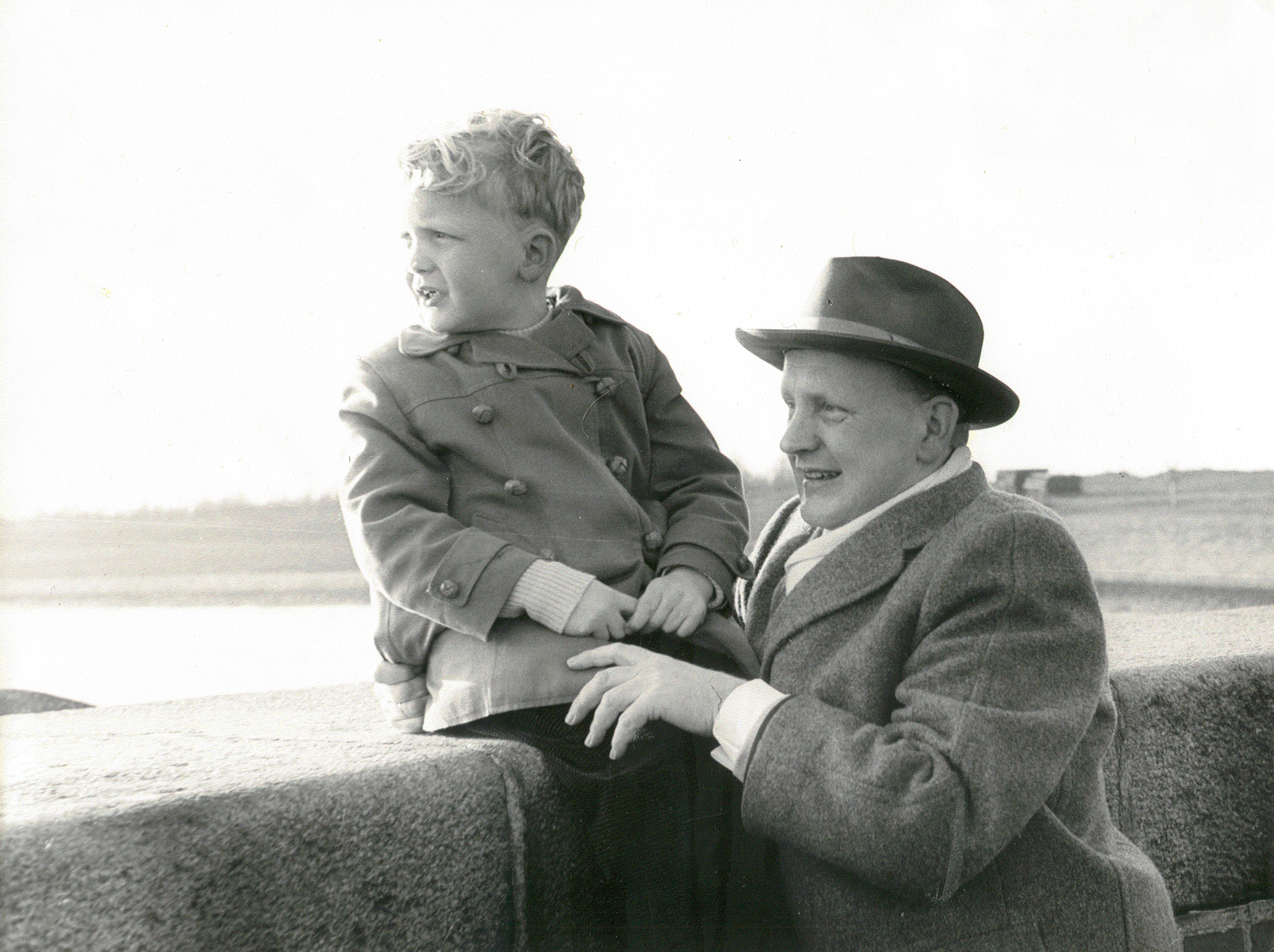 Schwarz-Weiß-Foto: Ein Emder mit seinem Sohn auf der Mole in Emden im Jahre 1960. Fotografin: I.O.