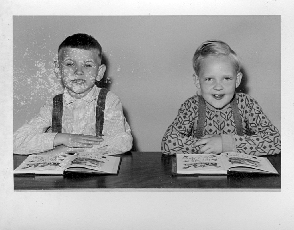 Zwei Schüler einer ersten Volksschulklasse hinter ihrer Schulbank und aufgeschlagenen Schulbüchern in der Hohnsenschule in Hildesheim im Jahr 1960.