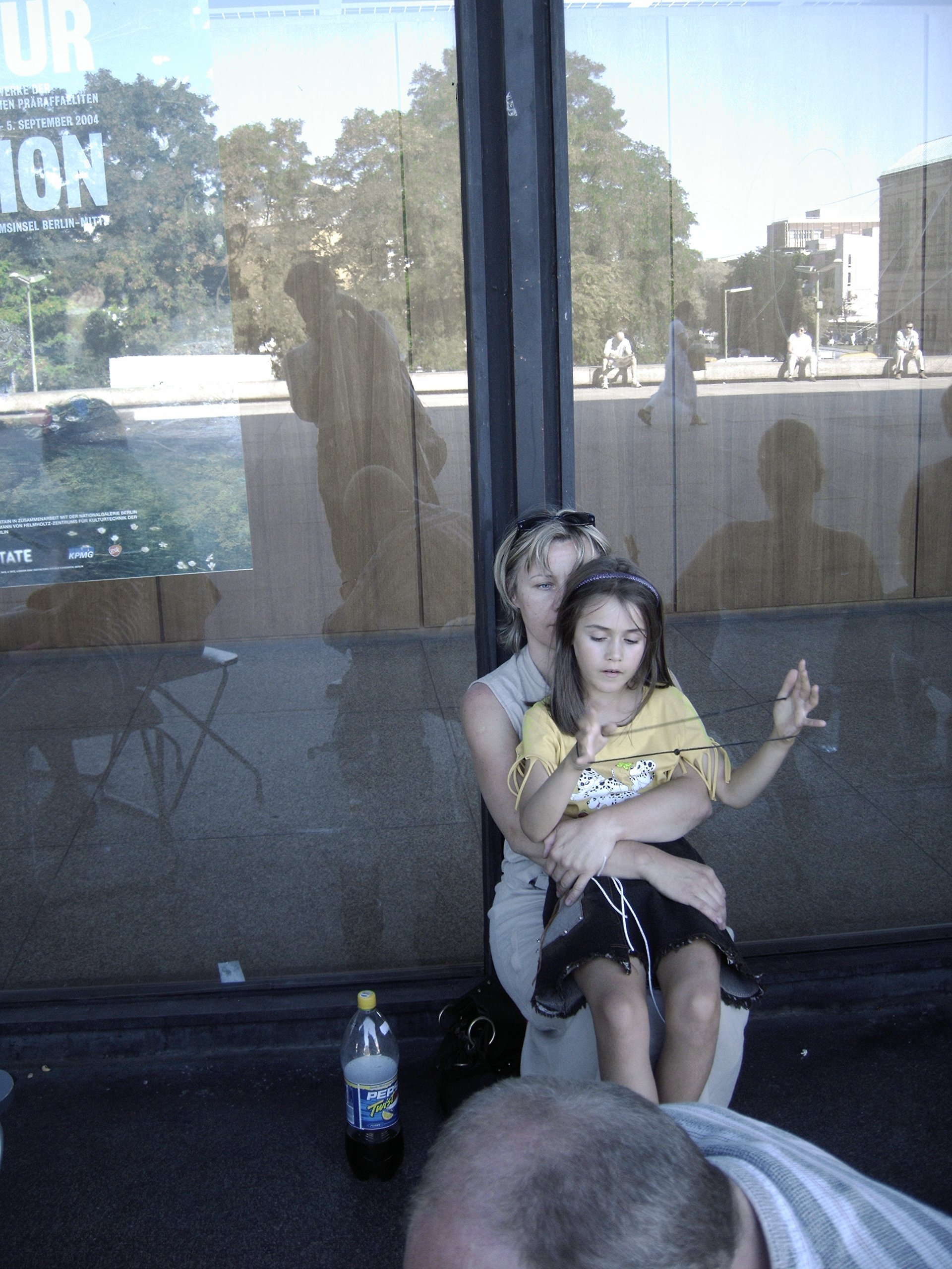 In der Schlange um die Neue Nationalgalerie in Berlin waehrend der Kunstausstellung Das MoMA in Berlin im September 2004: Eine Mutter mit ihrem spielenden Kind. Photo: Kim Hartley.