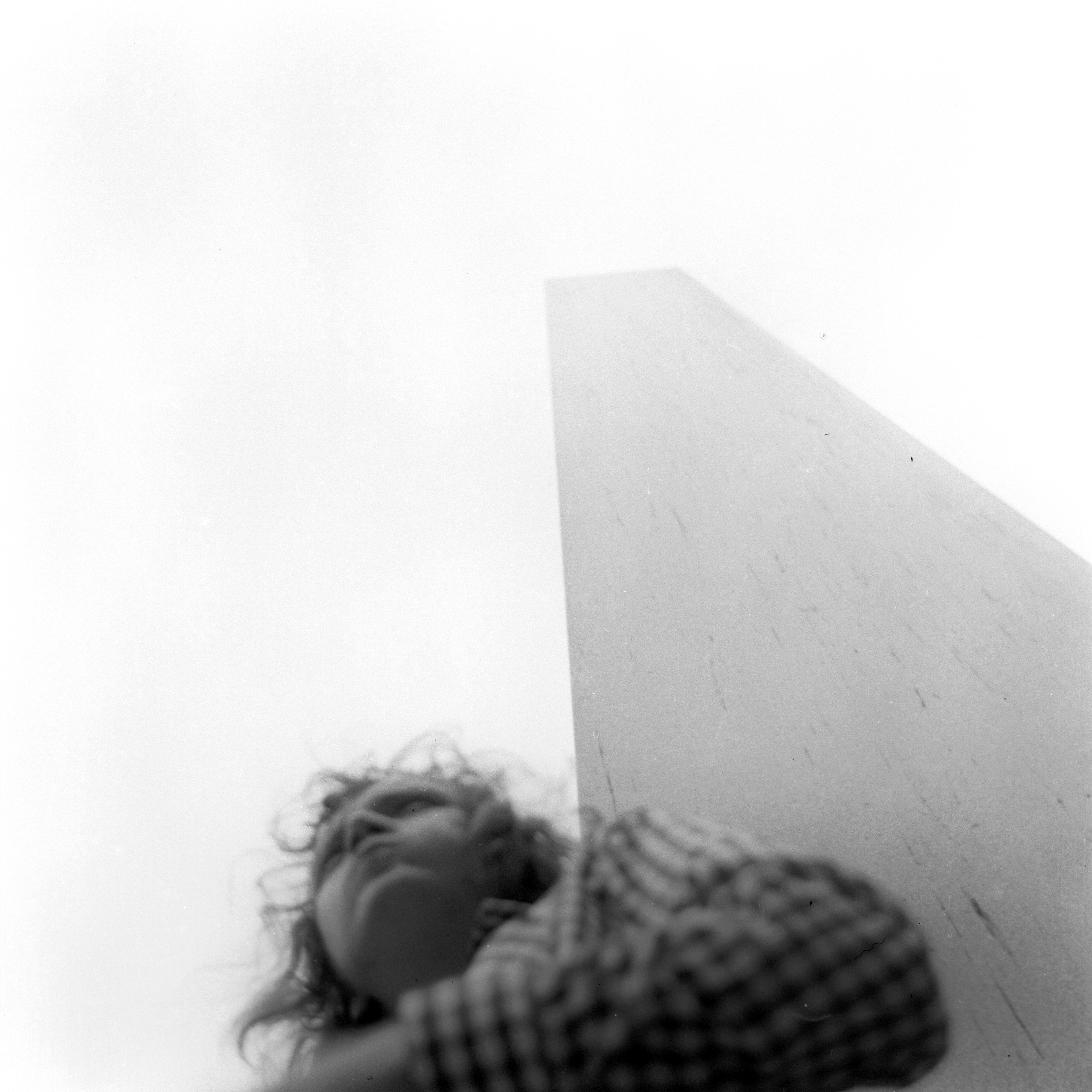 Schwarz-Weiß-Foto: Erwin Thomasius vor einer Plstik aus Stein an einem windigen Tag in Prag im Jahre 1973.