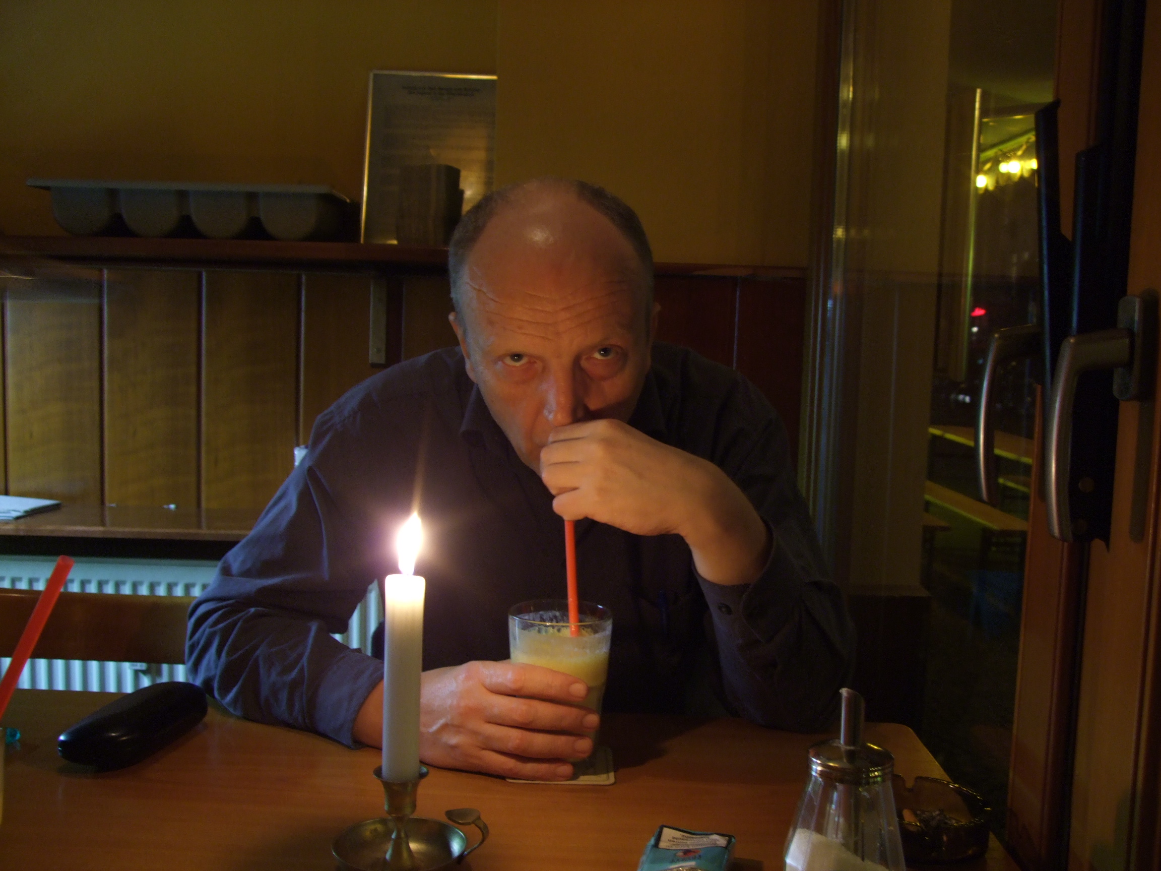 Farbphoto von Erwin Thomasius beim Trinken von Mangolassi in dem Indischen Restaurant in der Simon-Dach-Straße in Friedrichshain in Berlin in einer Nacht im Novermber 2007. Photo: Kim Hartley.