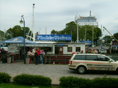 Farbfoto: Verkauf von Fischbrötchen und Backfisch von einem Schiff aus in Warnemünde im Jahre 2009. Und ein Taxi. Fotograf: Bernd Paepcke.