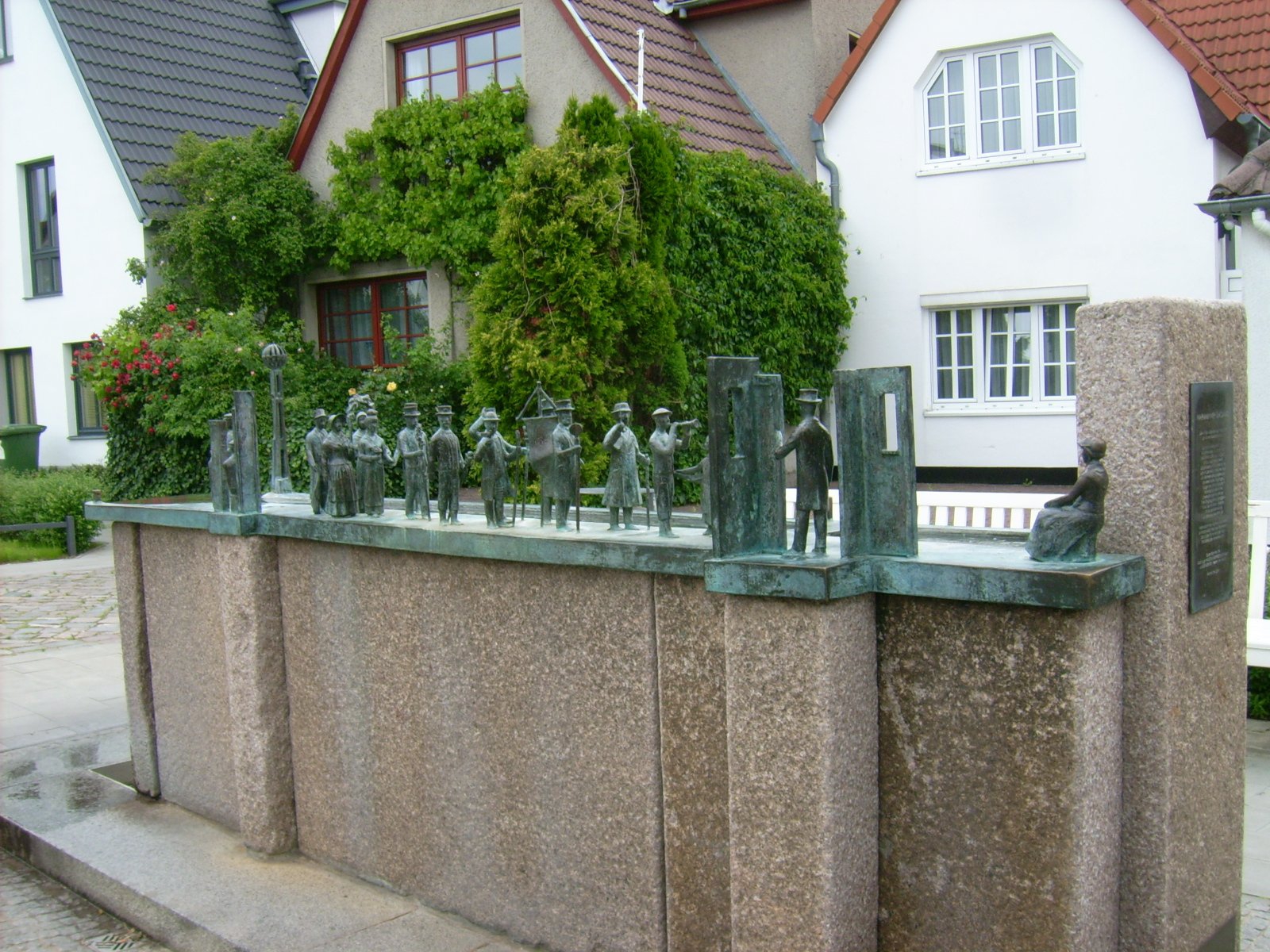 Farbfoto: Die Plastik WARNMINNER ÜMGANG von Wolfgang Friedrich in der Alexandrinenstraße in Warnemünde im Jahre 2009. Fotograf: Bernd Paepcke.